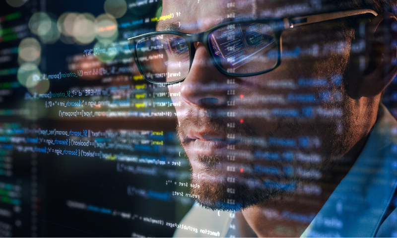 Viso di un MSP in primo piano mentre osserva lo schermo di un pc con dati di programmazione.