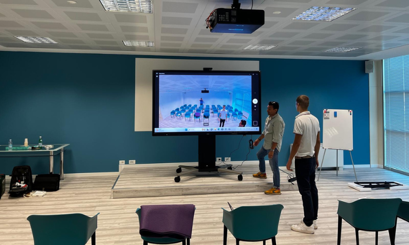 Tecnici al lavoro per l'installazione di un monitor interattivo.
