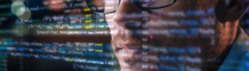 Viso di un MSP in primo piano mentre osserva lo schermo di un pc con dati di programmazione.