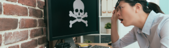 Una donna osserva incredula lo schermo di un pc dopo essere stata vittima di un attacco hacker o virus.