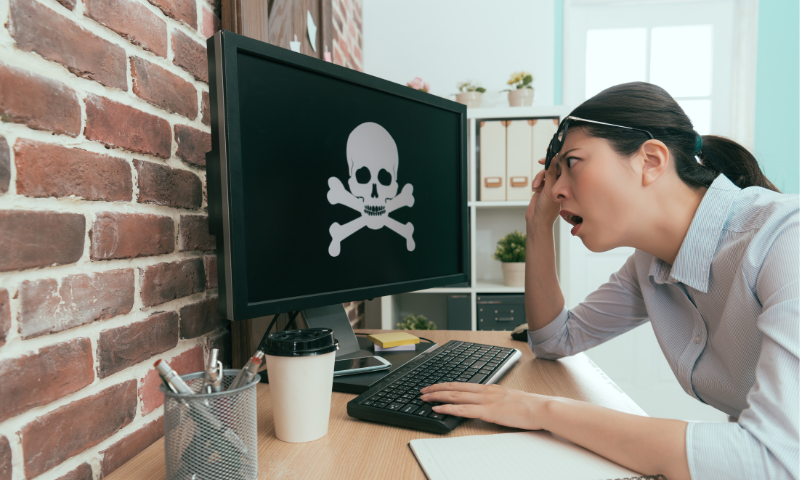 Una donna osserva incredula lo schermo di un pc dopo essere stata vittima di un attacco hacker o virus.